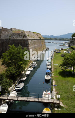 Bateaux amarrés dans le fossé défensif aux côtés d'un bastion de l'ancienne forteresse, Corfou Banque D'Images