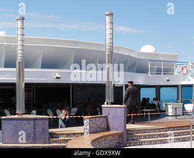 Avis de voyageurs dans un espace bar avec Young boy taking photograph of old manon pont principal de Minoan Lines Ferry Cruise Olympia Banque D'Images