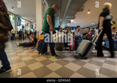 Passagers en salle d'embarquement à l'aéroport Galileo Galilei en attente de leur vol, Pise, Toscane, Italie Banque D'Images