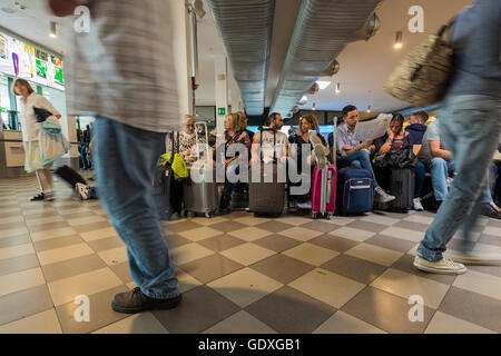 Passagers en salle d'embarquement à l'aéroport Galileo Galilei en attente de leur vol, Pise, Toscane, Italie Banque D'Images