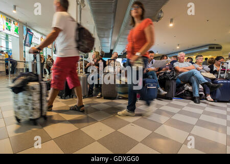 Passagers en salle d'embarquement à l'aéroport Galileo Galilei en attente de leur vol, Pise, Toscane, Italie Banque D'Images