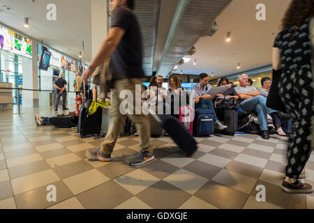 Passagers en salle d'embarquement à l'aéroport Galileo Galilei en attente de leur vol, Pise, Toscane, Italie Banque D'Images