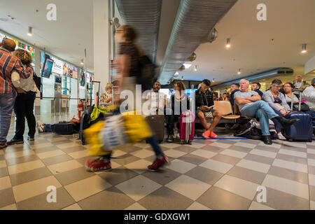 Passagers en salle d'embarquement à l'aéroport Galileo Galilei en attente de leur vol, Pise, Toscane, Italie Banque D'Images