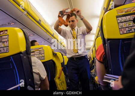 Homme d'équipage de cabine Ryanair démontrant les procédures de sécurité avant le départ, Banque D'Images