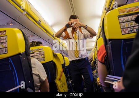 Homme d'équipage de cabine Ryanair démontrant les procédures de sécurité avant le départ, Banque D'Images