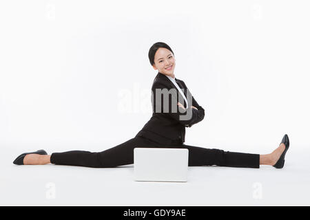 Smiling business woman étend ses jambes bras repliable avec un ordinateur portable Banque D'Images