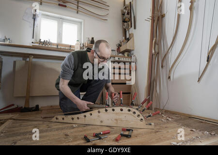 Bois fixation mâle archetier archet en forme en atelier, Bavière, Allemagne Banque D'Images