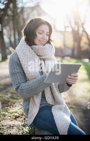 Mature Woman using digital tablet in the park et souriant, Bavière, Allemagne Banque D'Images