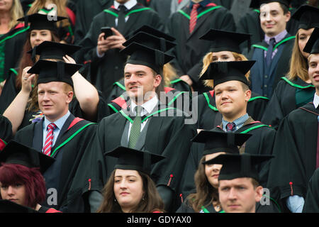 L'enseignement supérieur au Royaume-Uni : un groupe d'étudiants de l'université d'Aberystwyth portant des robes traditionnelles, capes et conseils mortier préparatifs d'avoir leur photo de groupe prise à leur remise des diplômes cérémonie, Juillet 2016 Banque D'Images