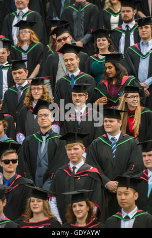 L'enseignement supérieur au Royaume-Uni : un groupe d'étudiants de l'université d'Aberystwyth portant des robes traditionnelles, capes et conseils mortier préparatifs d'avoir leur photo de groupe prise à leur remise des diplômes cérémonie, Juillet 2016 Banque D'Images