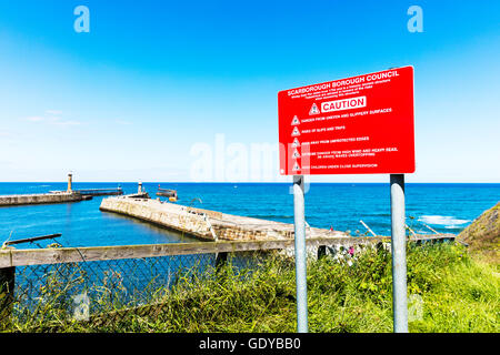 Falaises de Whitby panneau d'avertissement danger dangereux glissement des surfaces glissantes dangers signalisation Yorkshire UK Angleterre GO Banque D'Images