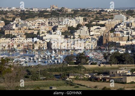 Bateaux de pêche peintes de couleurs vives (appelés Luzzu) dans le port du village de pêcheurs de Marsaxlokk, dans le sud de l'île de Malte. La photo a été prise en avril 2014. À droite est la paroisse "Notre-Dame de Pompéi". Photo : Tom Schulze | conditions dans le monde entier Banque D'Images