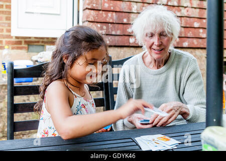 Une race mixte enfant joue d'enfant avec sa grand-mère, Sussex, UK Banque D'Images