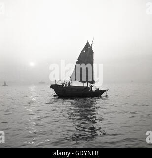 Années 1950, histoire, soirée et une vieille jonque chinoise amarrée dans les eaux calmes du port d'Aberdeen, Hong Kong. Banque D'Images