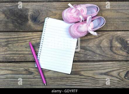 Ordinateur portable blanc et rose chaussures sur table en bois Banque D'Images