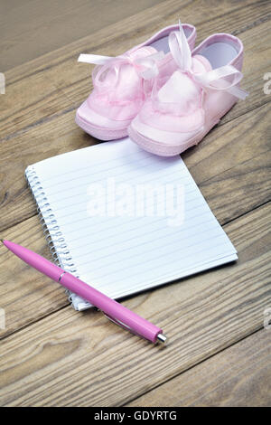 Ordinateur portable blanc et rose chaussures sur table en bois Banque D'Images