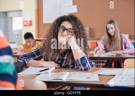 Étudiant universitaire soufflant du bubblegum en classe, Bavière, Allemagne Banque D'Images