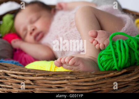 Cute baby girl sleeping with ball de laines dans panier, Fürstenfeldbruck, Bavière, Allemagne Banque D'Images