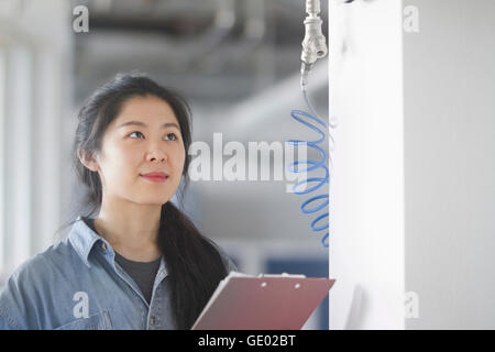 Jeune femme ingénieur travaillant dans une usine industrielle, Freiburg im Breisgau, Bade-Wurtemberg, Allemagne Banque D'Images