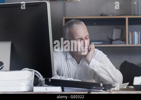 Senior businessman assis au bureau et chambre, Freiburg im Breisgau, Bade-Wurtemberg, Allemagne Banque D'Images