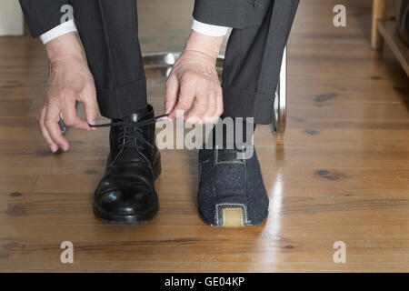 La section basse d'un businessman tying shoelace, Freiburg im Breisgau, Bade-Wurtemberg, Allemagne Banque D'Images