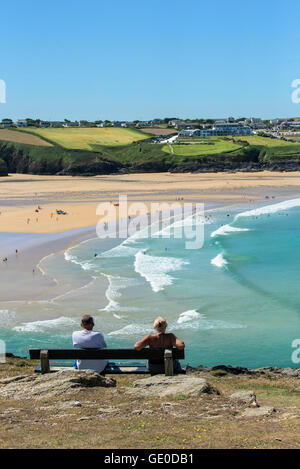 Les touristes se détendre sur un banc avec vue sur la plage de Crantock primé à Newquay Cornwall UK. Banque D'Images