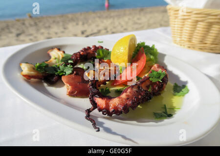 Poulpe Grillé avec une tranche de citron et d'olive sur une plaque par la mer. Banque D'Images