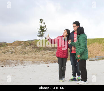 Selfie à la plage avec trois personnes en hiver Banque D'Images