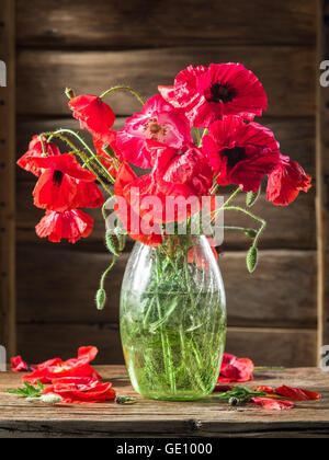 Bouquet de fleurs de pavot dans le vase sur la table en bois. Banque D'Images