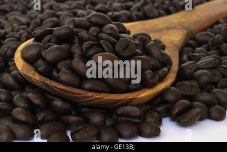 Coffee bean seed sur cuillère en bois isolé sur un fond blanc. Banque D'Images