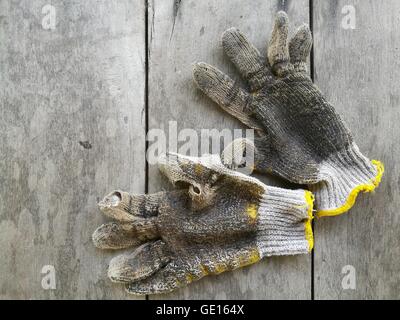 Des gants sales sur fond sombre Banque D'Images