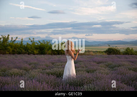 Femme debout dans un champ de lavande Banque D'Images