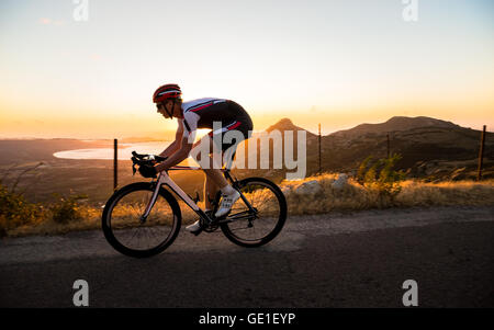 Homme randonnée à vélo au coucher du soleil, Corse, France Banque D'Images