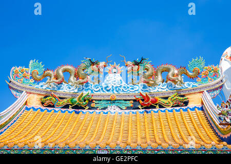 Dragons jumeaux colorés sur les sculpture temple chinois de toit avec ciel bleu Banque D'Images