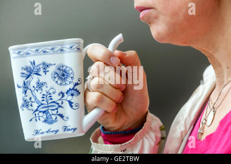 Femme buvant de l'eau minérale, tasse de porcelaine modèle d'oignon Karlovy Vary République tchèque Banque D'Images