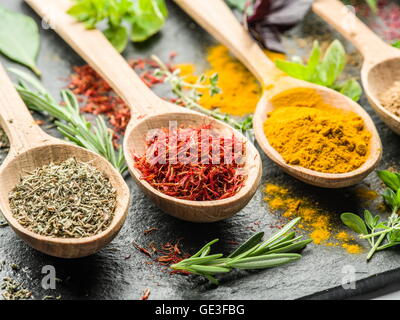 Assortiment d'épices colorées dans l'cuillères en bois. Banque D'Images