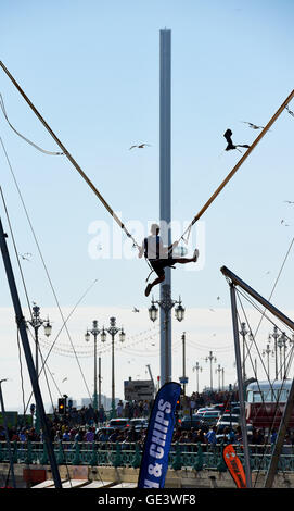 Brighton Sussex UK 23 Juillet 2016 - Un jeune homme jouit d'une ride sur le front de saut dans le contexte de la British Airways j360 tour d'observation que des milliers affluent à la plage de Brighton que le soleil sort finalement après une matinée de Misty météo . La tour i360 est en raison d'ouvrir au public le 4 août cette année Crédit : Simon Dack/Alamy Live News Banque D'Images