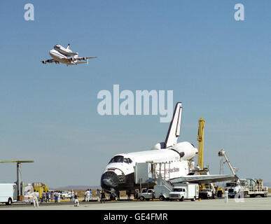 La navette spatiale Endeavour reçoit une salve de haut vol de sa sœur de la navette Columbia, au sommet de l'avion porteur de la NASA Navette, peu après son atterrissage le 12 octobre 1994 à Edwards, en Californie, afin de remplir la mission STS-68. Colombie-britannique entre le Centre spatial Kennedy, en Floride, pour Air Force Plant 42, Palmdale, Californie, où il va subir six mois d'inspections, de modifications et de mises à niveau des systèmes. Le STS-68 mission de 11 jours a été consacrée à l'imagerie radar de la géologie avec l'espace laboratoire radar. L'orbiteur est entouré par de l'équipement et du personnel que m Banque D'Images