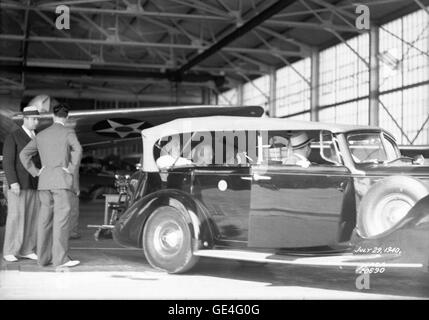 (29 juillet 1940) Le président Franklin D. Roosevelt a visité Langley Field le 29 juillet 1940. Avis du président Roosevelt dans une voiture à l'intérieur d'un hangar de la NACA, deux hommes non identifiés se tenir derrière la voiture, et l'aile d'un avion est visible dans l'arrière-plan. Image #  : L-20690 Banque D'Images