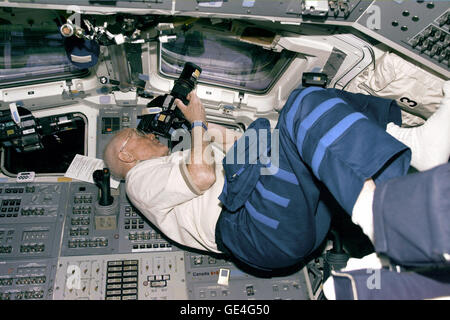 (30 octobre 1998), STS-95 Spécialiste de charge utile de John Glenn se positionne pour prendre des photos à partir de la découverte, ce poste de pilotage arrière windows sur Jour de vol 3. Image #  : S95E5190 Banque D'Images