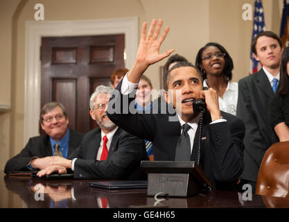 Le président américain Barack Obama, accompagné par des membres du Congrès et les enfants de l'école intermédiaire, les vagues comme il parle au téléphone de la Roosevelt Room de la Maison blanche aux astronautes de la Station spatiale internationale, le mercredi 17 février 2010 à Washington. Image #  : 2010-02-17-0001AC Date : 17 février 2010 Crédit photo : NASA/Bill Ingalls) Banque D'Images