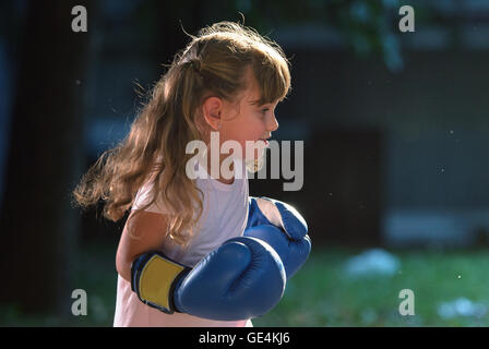 Petite fille portant des gants de boxe bleu Banque D'Images