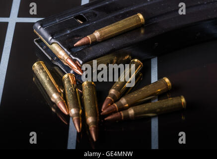 Des munitions dans les magazines sur la surface noire .223/556 Banque D'Images