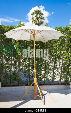 Meubles en bois couverts par parapluie dans jardin et ciel bleu Banque D'Images