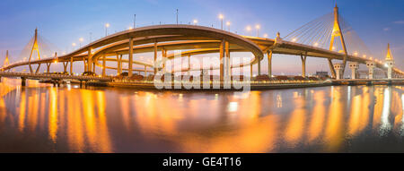 Pont suspendu moderne et de l'autoroute riverside incurvé au crépuscule d'une lumière dorée de scène Banque D'Images