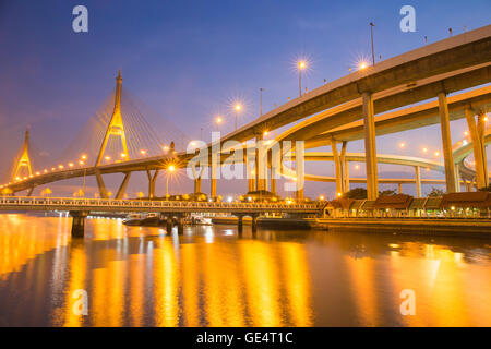 Pont suspendu moderne et de l'autoroute riverside incurvé au crépuscule d'une lumière dorée de scène Banque D'Images