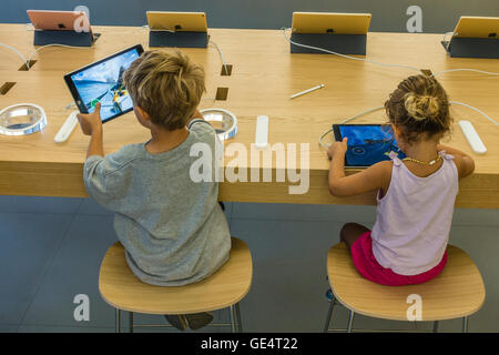 Deux enfants, 6-8 ans essayer d'ipad à l'Apple Store sur la State Street à Santa Barbara, en Californie. Banque D'Images