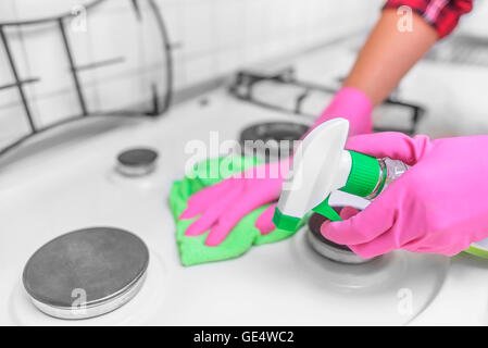 Les mains dans les gants sont lavés la cuisinière à gaz. Close-up. Banque D'Images