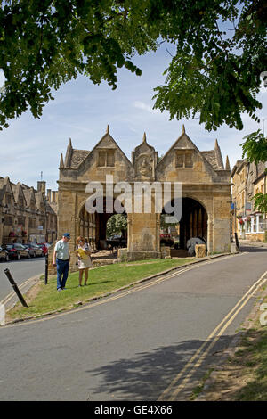 Deux personnes à la carte à l'extérieur en pierre de Cotswold market hall tetbury érigé en 1627 uk cotswolds Banque D'Images