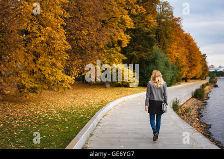 Corps complet de woman walking in autumn park. Scène du parc urbain. Près de River Embankment. Vue arrière. Banque D'Images